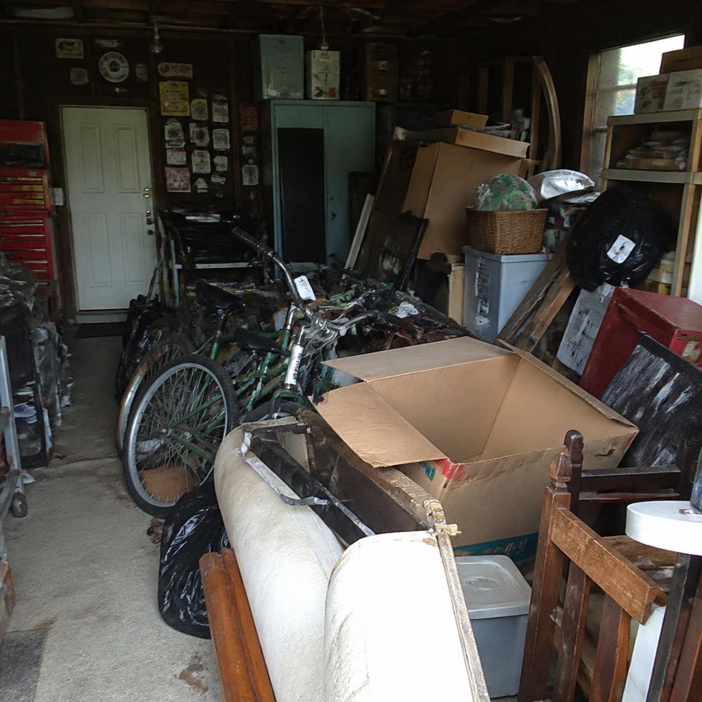 Garage packed with boxes, bikes and old furniture before a clean out